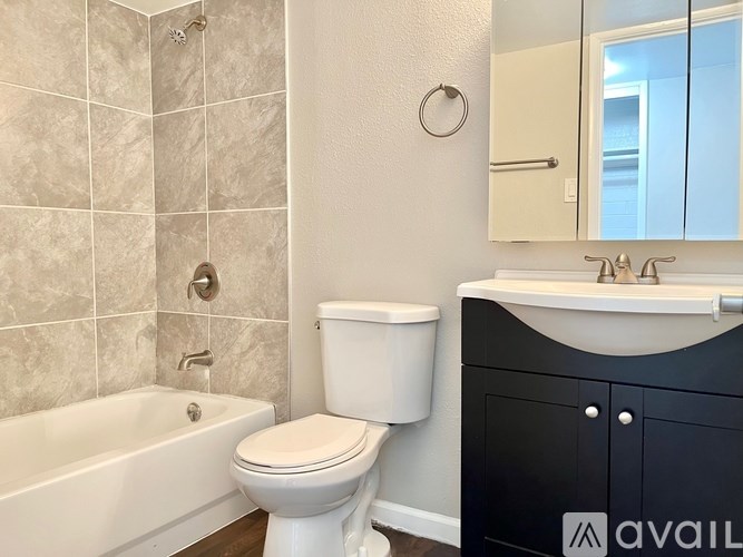 A bathroom with a white toilet, a bathtub, and a sink.