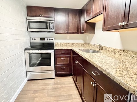 A kitchen with wooden cabinets and a granite countertop.