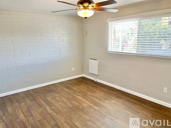 A room with a ceiling fan and a window with blinds.