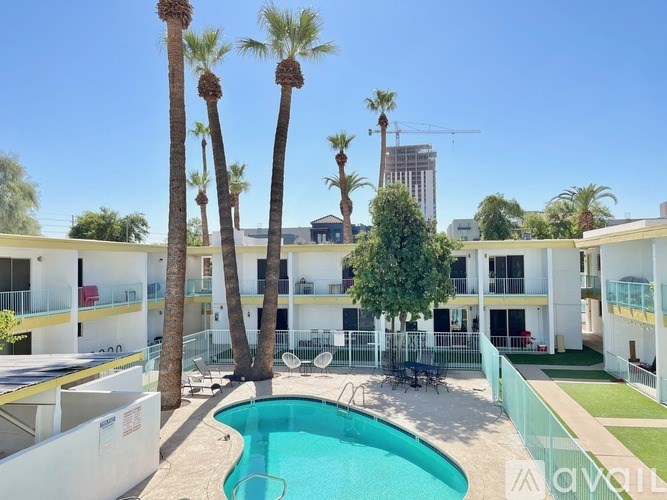 A pool surrounded by palm trees and apartment buildings.