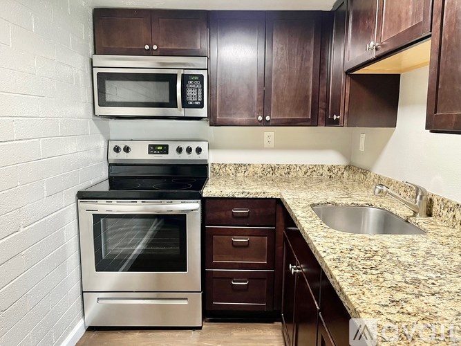 A kitchen with a stove top oven and microwave above it.