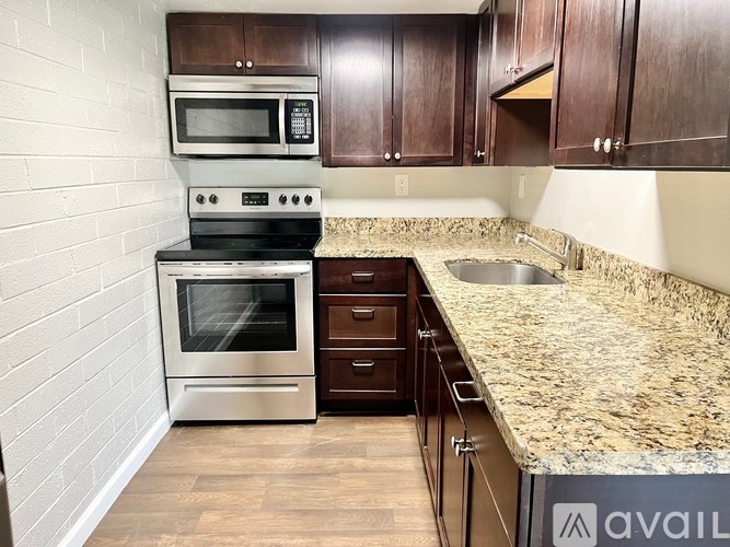 A kitchen with a granite countertop and stainless steel appliances.