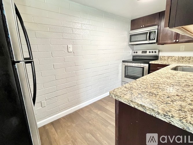 A kitchen with a granite countertop and a refrigerator.