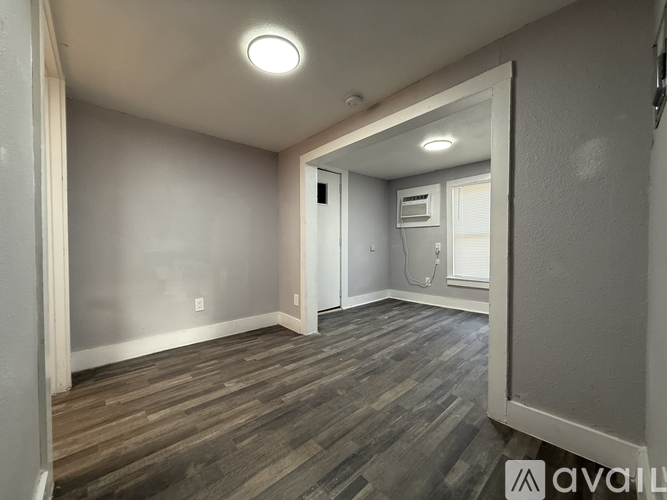 A room with wooden flooring and a white door.