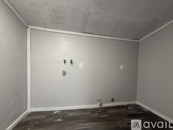 A room with a white wall and a wooden floor.