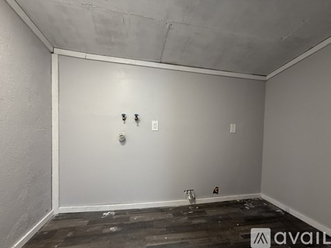 A room with a white wall and a wooden floor.