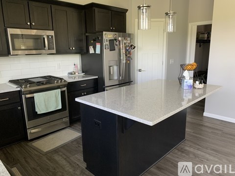A kitchen with black cabinets and a granite countertop.