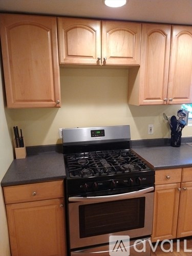A kitchen with wooden cabinets and a black stove top.