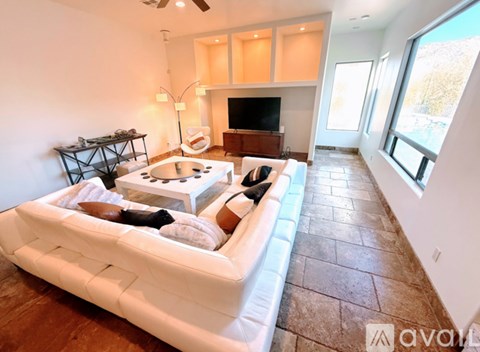 A living room with a white couch and a television.