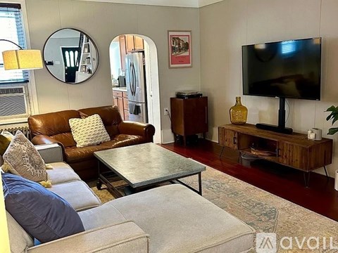 A living room with a brown leather couch and a grey sofa.