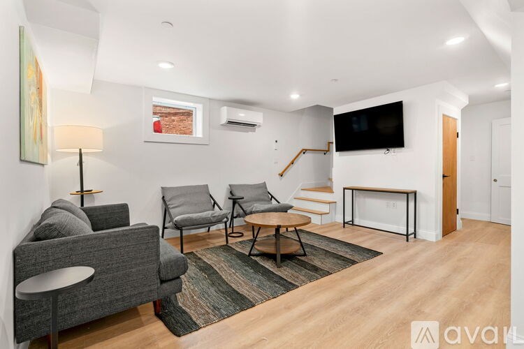 A living room with a grey couch, a coffee table, and a television.