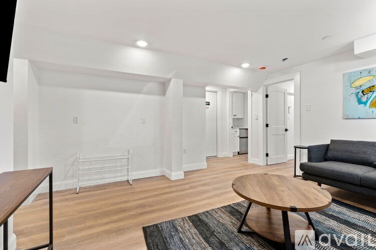 A living room with a grey couch and a wooden coffee table.