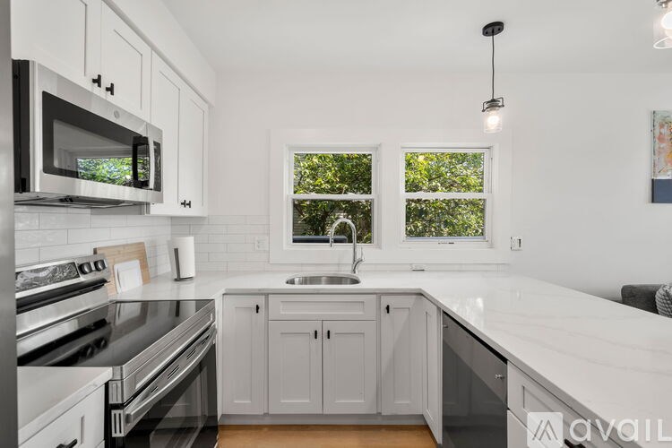 A modern kitchen with a stainless steel oven and white cabinets.