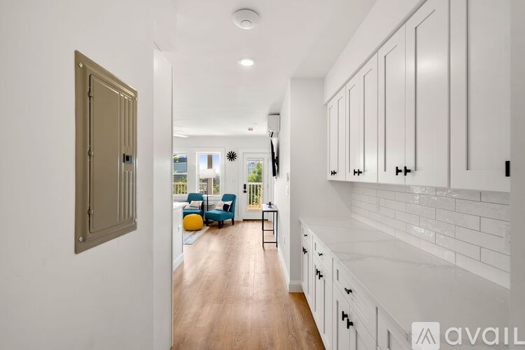 A kitchen with white cabinets and a wooden floor.