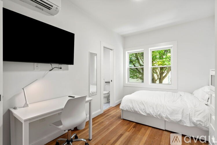 A bedroom with a bed, desk, and chair.