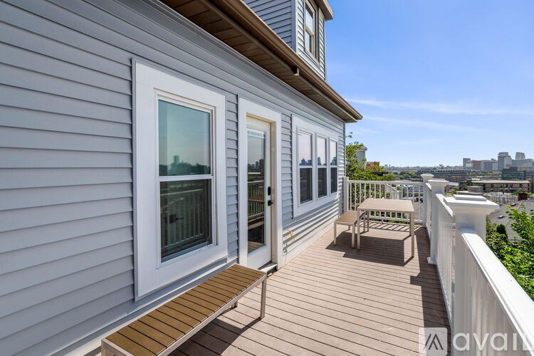 A balcony with a bench and a view of the city.