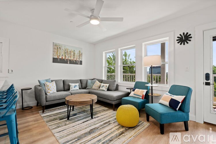 A living room with a grey couch, a yellow ball, and a blue chair.