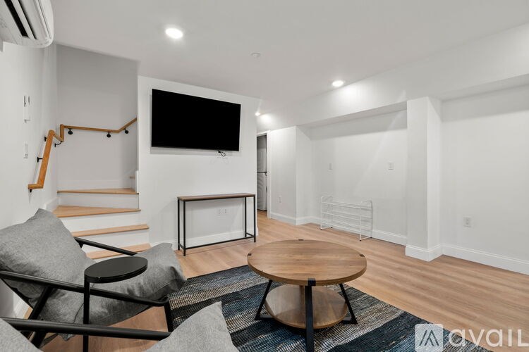 A living room with a television, a chair, and a coffee table.