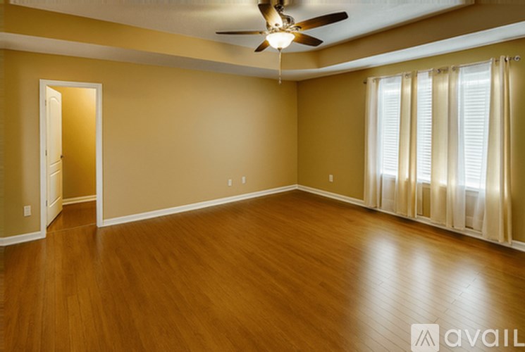A room with wooden floors and a ceiling fan.