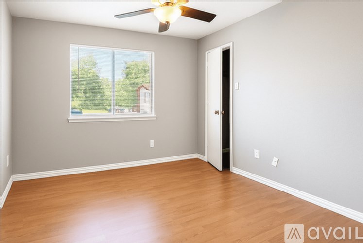 A room with wooden flooring and a ceiling fan.
