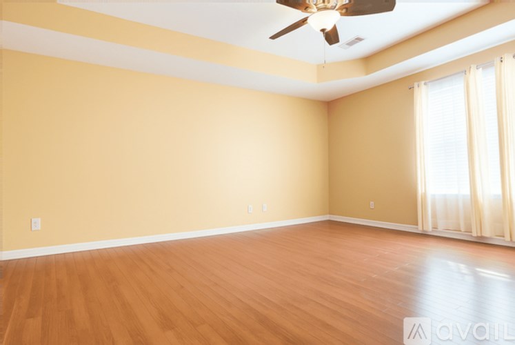A room with wooden floors and a ceiling fan.