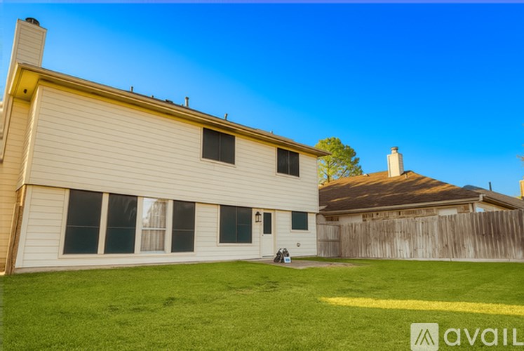 A house with a fence and a tree in the yard.