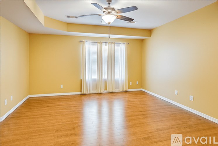 A room with wooden flooring and a ceiling fan.