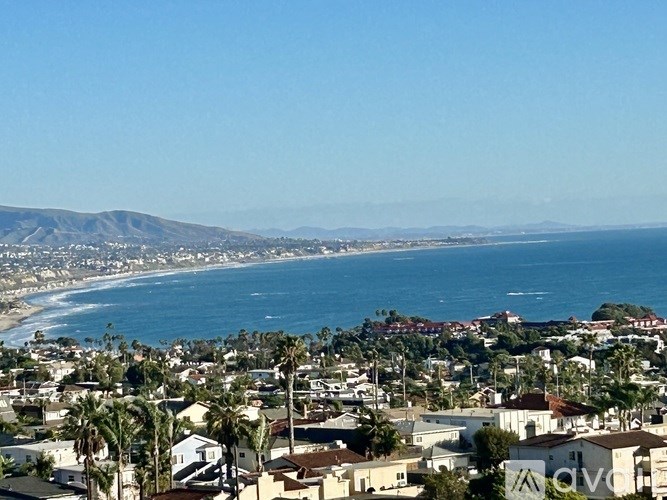 A coastal town with a view of the ocean and mountains in the distance.