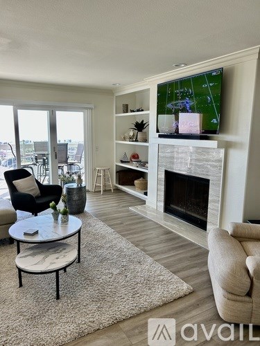 A living room with a fireplace and a television on the wall.
