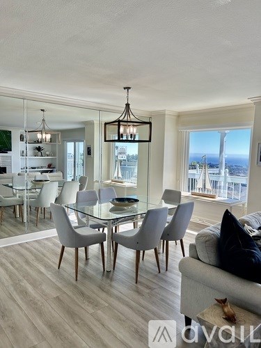 A modern dining room with a glass table and chairs.