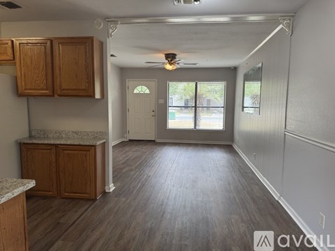 A kitchen area with wooden cabinets and a marble countertop.