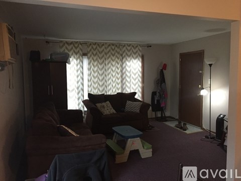 A living room with a brown couch and a blue blanket.