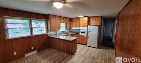 A kitchen with wooden cabinets and a white refrigerator.