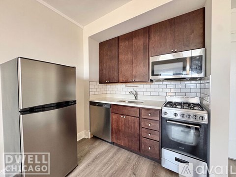 A kitchen with a white fridge, white stove and wooden cabinets.