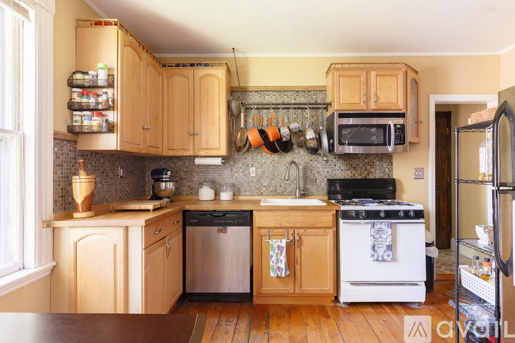 A kitchen with wooden cabinets and a stove top oven.