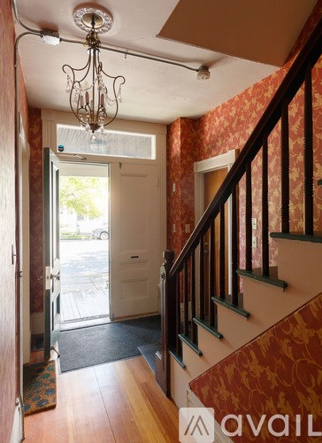 A hallway with a chandelier and a staircase.