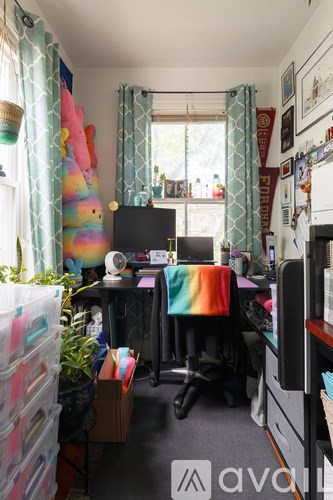 A room with a desk, a computer, and a chair.