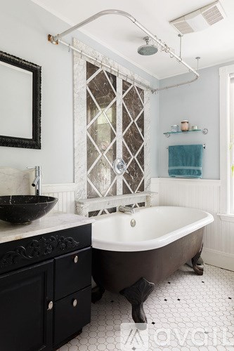 A black and white bathroom with a claw foot tub.