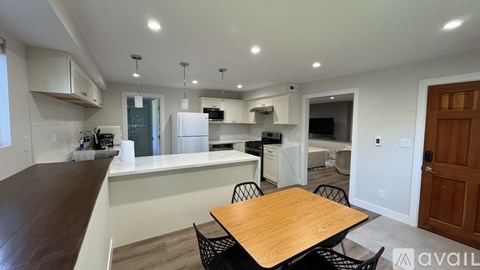 A kitchen with a table and chairs in the middle of the room.