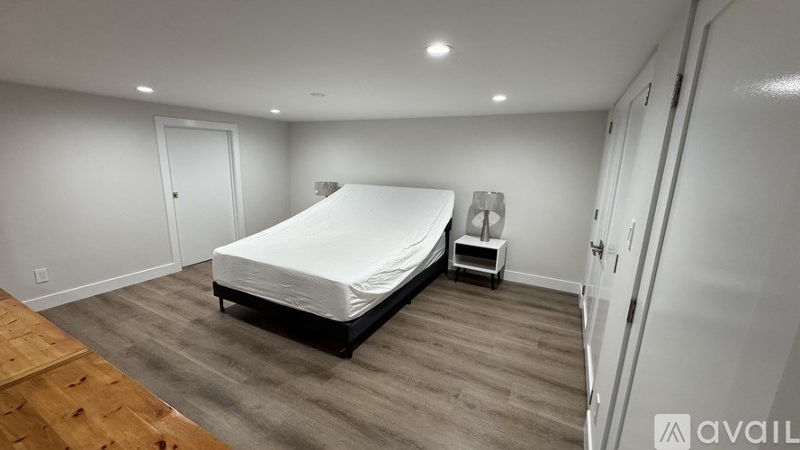 A bedroom with a bed, nightstand, and chair.