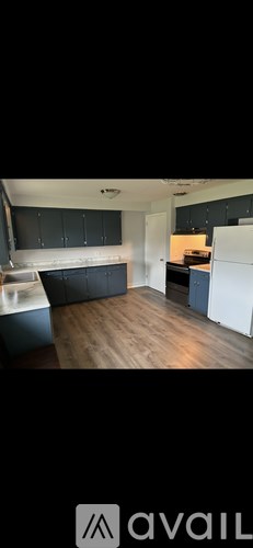 A kitchen with dark wood cabinets and a wooden table.