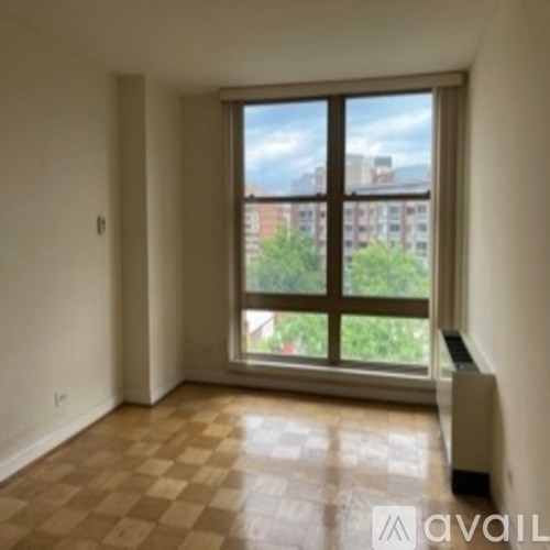 A room with a large window and a radiator on the floor.