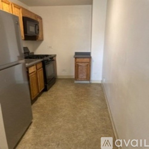 A kitchen with a refrigerator, microwave, and stove.