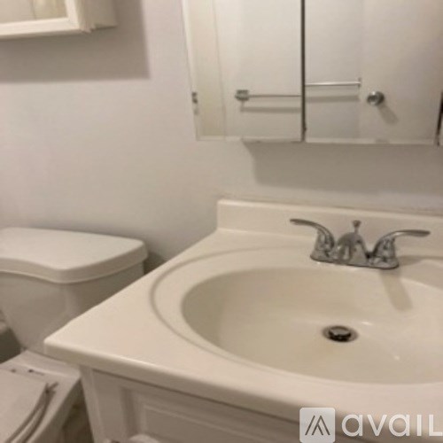 A white toilet sits next to a sink in a bathroom.