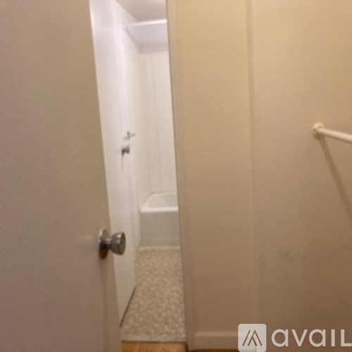 A white door with a silver handle is open.