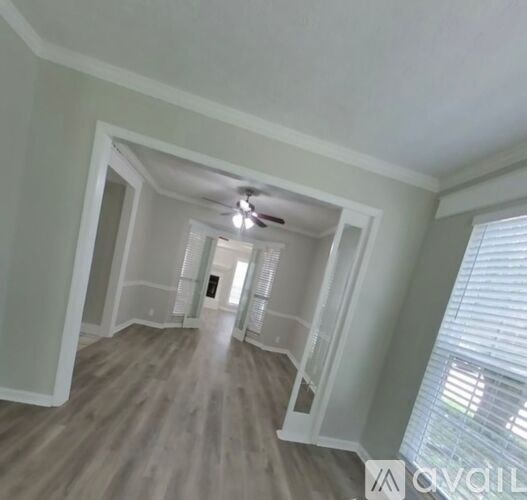 A spacious room with a ceiling fan and lighting fixture.