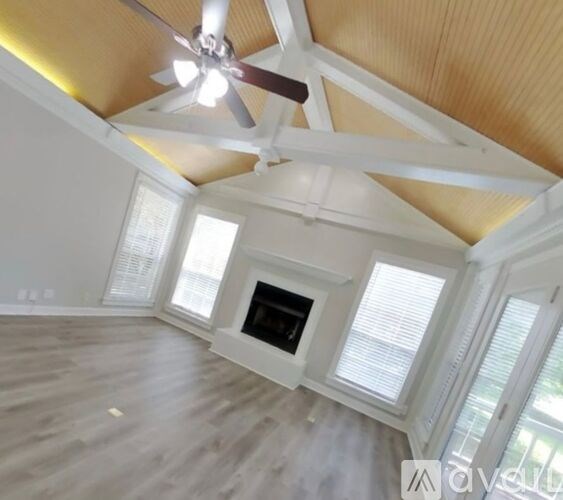 A living room with a fireplace and a ceiling fan.