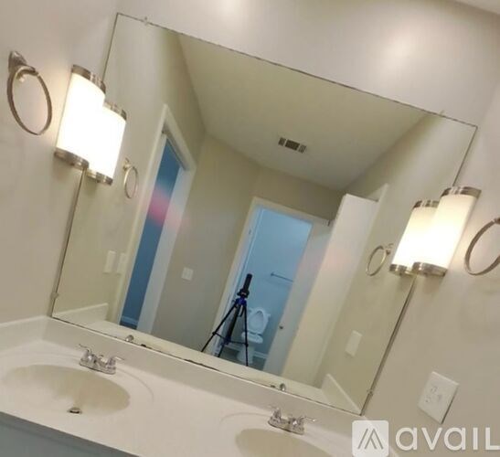 A bathroom with a sink, mirror, and lights.