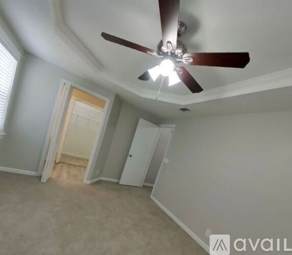A room with a ceiling fan and a window.
