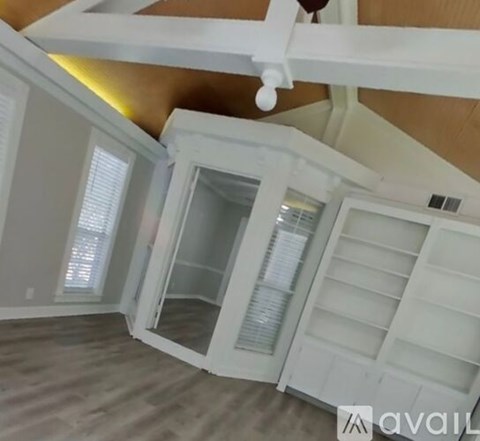 A kitchen with white cabinets and a wooden ceiling.
